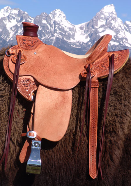 Light weight Lady's Wade Saddle with Custom copper rose and blue bells floral tooling with hand painted dyed background all dallied in a Vaquero Lace border. Contact us about a saddle made just for you like this one.